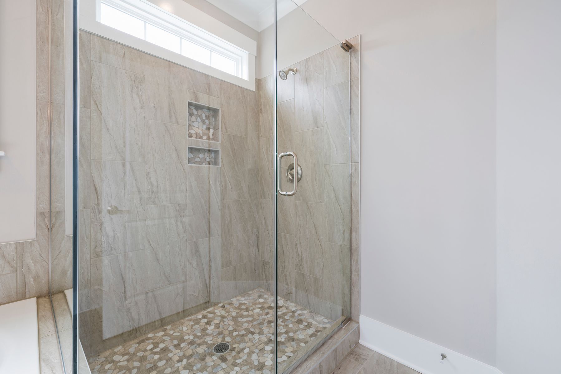 Glass shower enclosure with marble walls