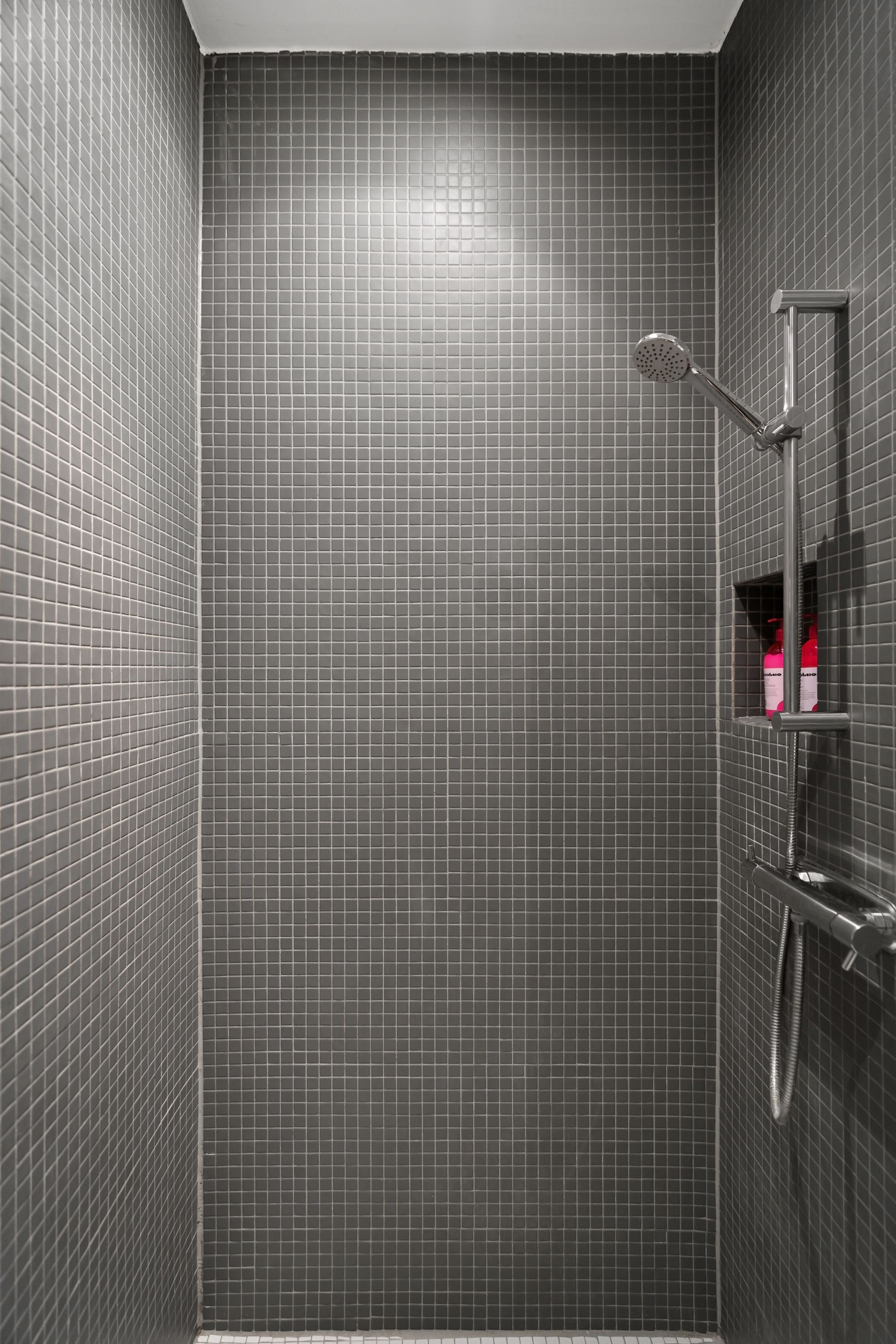 Modern grey-tiled shower with steel fittings