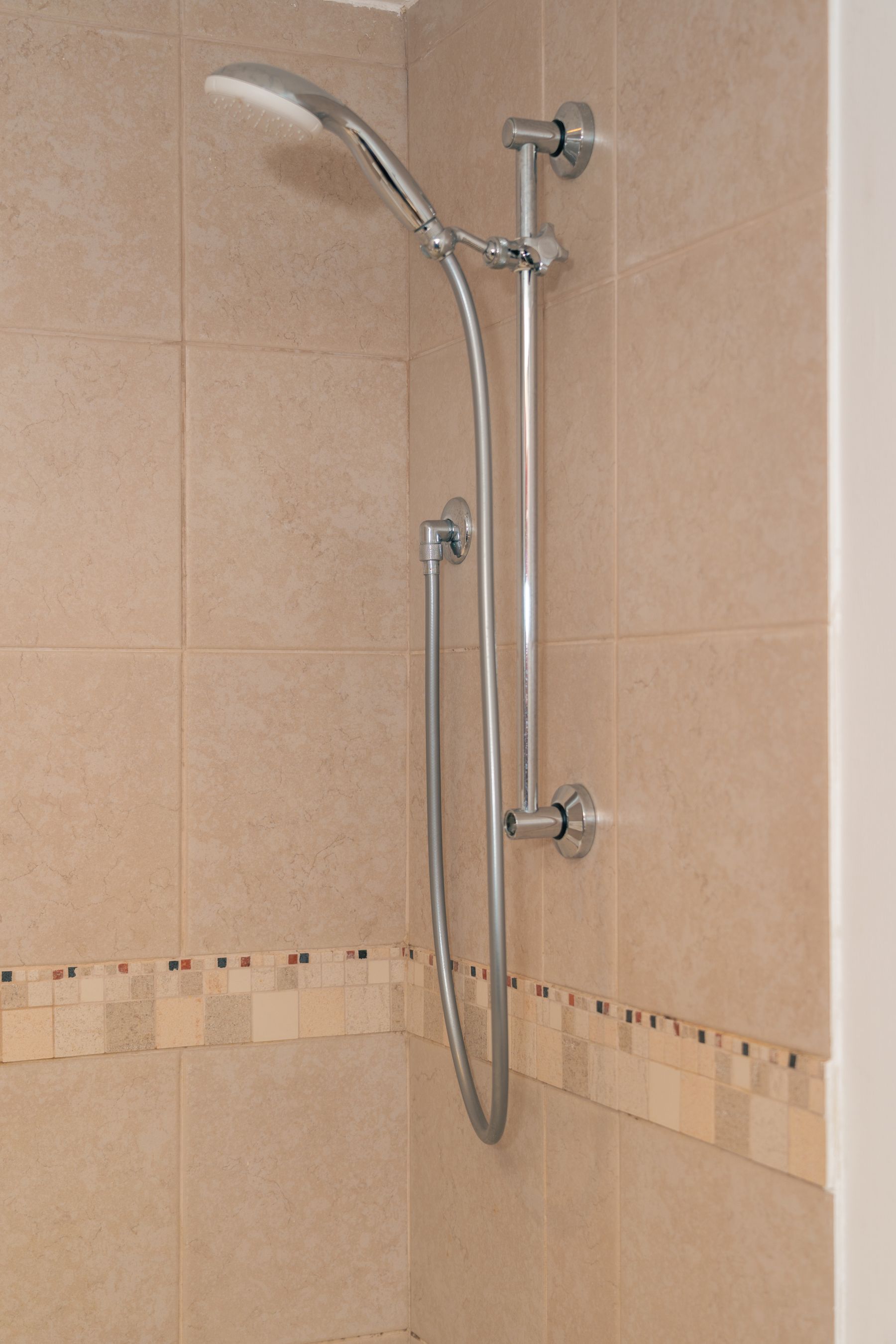 Chrome shower fitting in a tiled bathroom